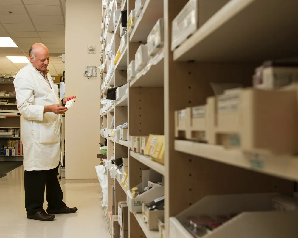 Pharmacist checking stock on pharmacy shelves